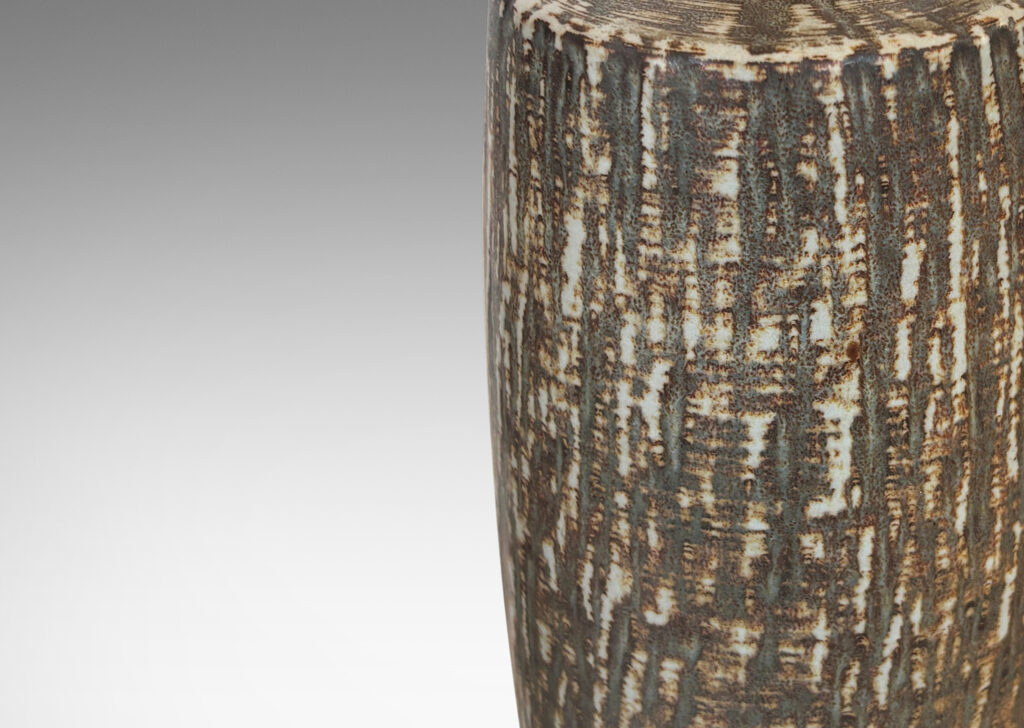 Gallery BAC swelling cylindrical forms with carved gouged surface and flowing brown glaze