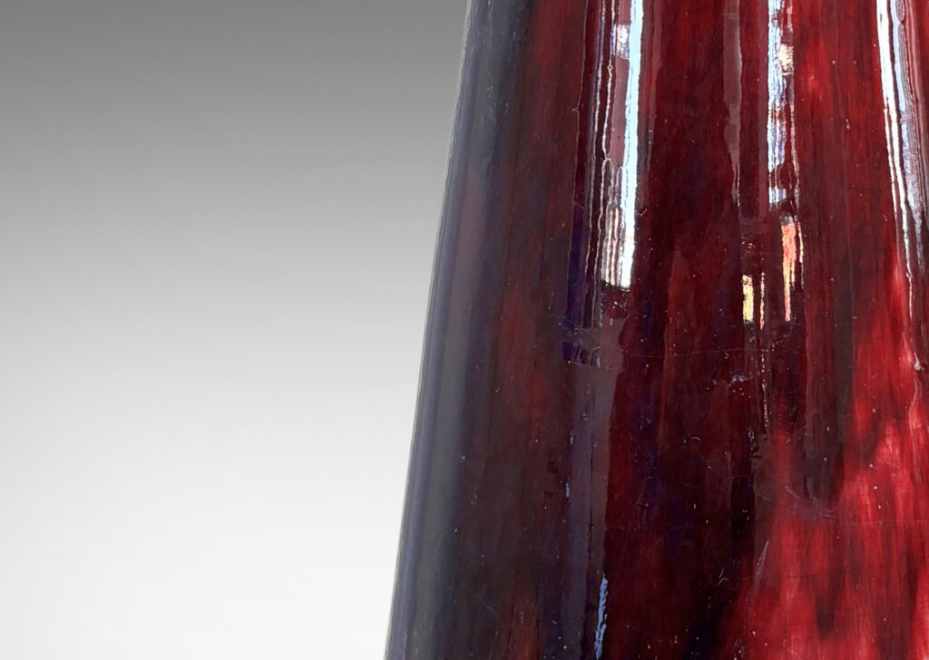 Gallery BAC tall flared form with trumpet mouth, glazed in a flowing oxblood with pale gray accents