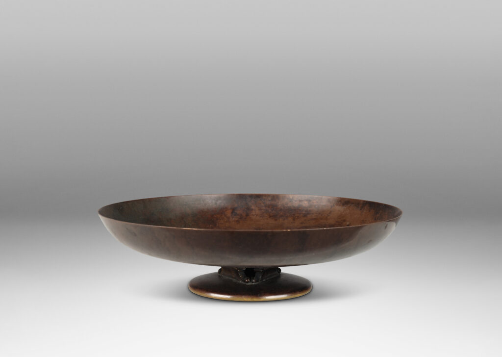 Gallery BAC shallow bowl form on a low stand mounted with baroque modeled brackets, with rich dark patination; bronze
