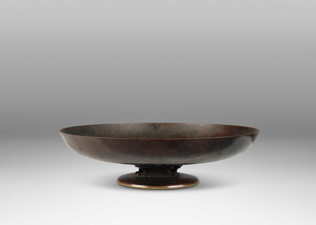 Gallery BAC shallow bowl form on a low stand mounted with baroque modeled brackets, with rich dark patination; bronze