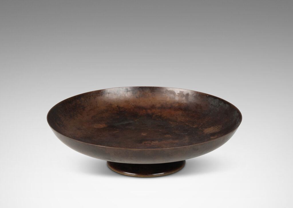 Gallery BAC shallow bowl form on a low stand mounted with baroque modeled brackets, with rich dark patination; bronze