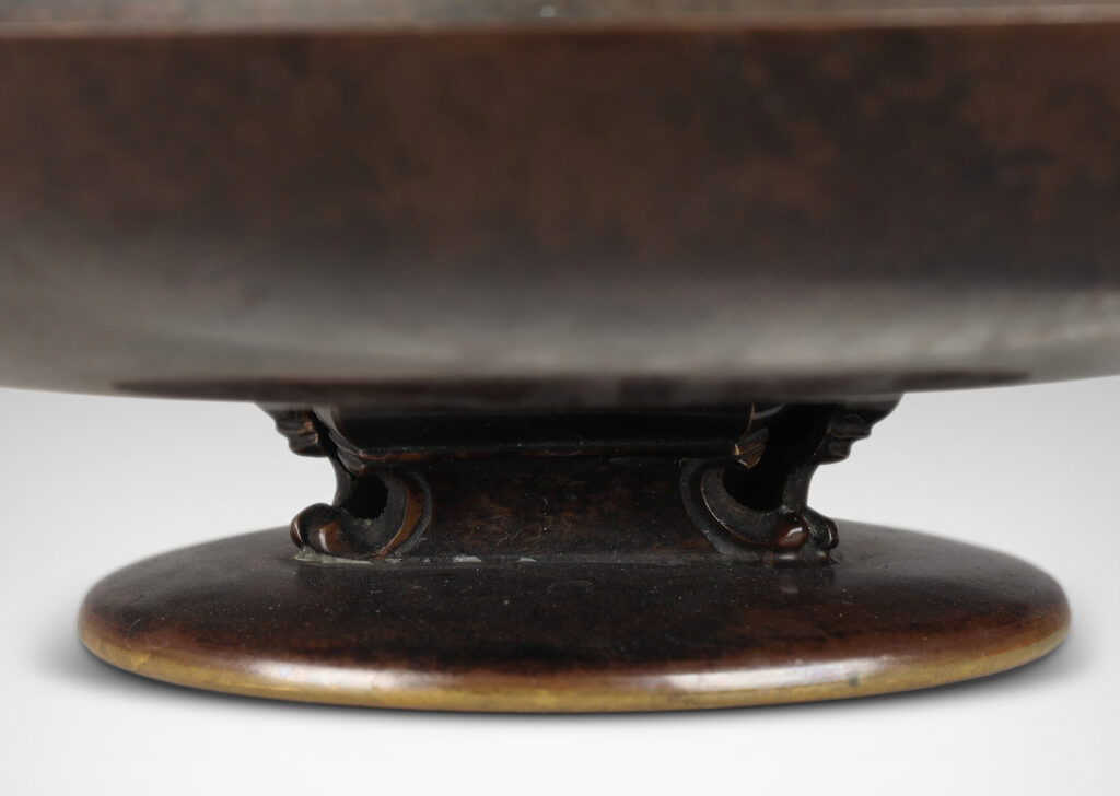 Gallery BAC shallow bowl form on a low stand mounted with baroque modeled brackets, with rich dark patination; bronze