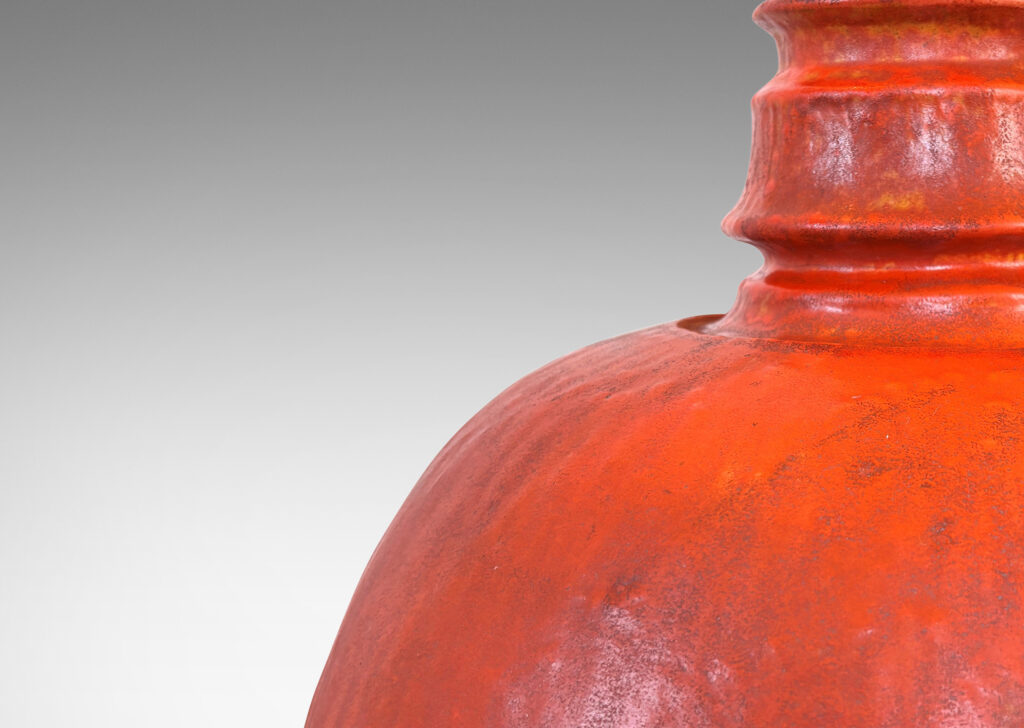 Gallery BAC ovoid form and notched neck with carved surface texture, glazed in orange with gray accents