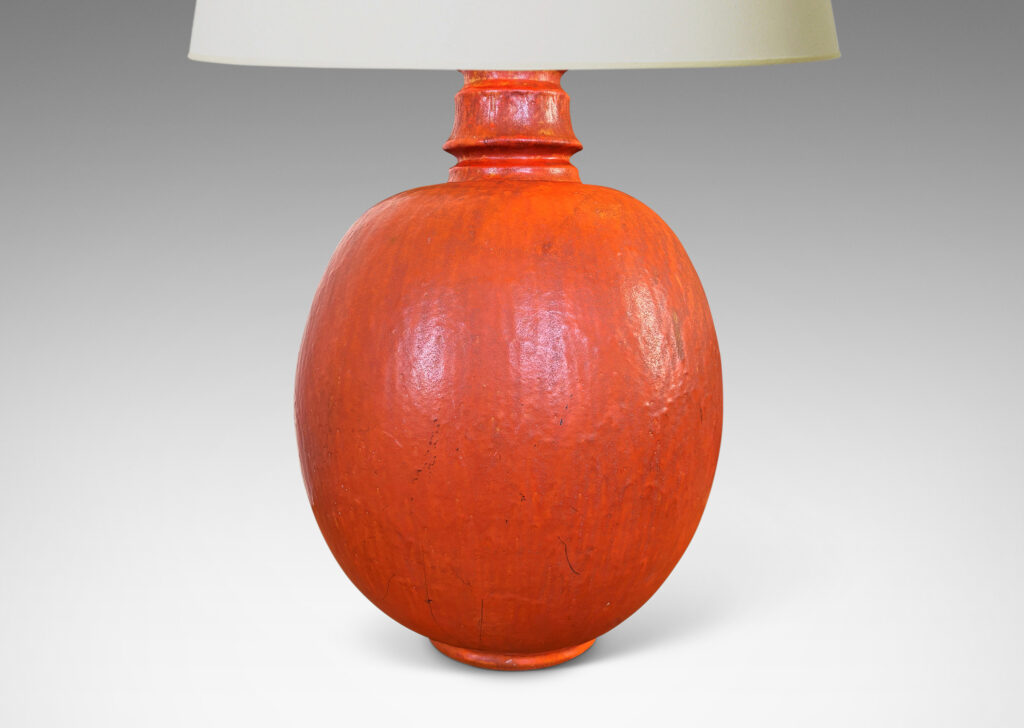 Gallery BAC ovoid form and notched neck with carved surface texture, glazed in orange with gray accents