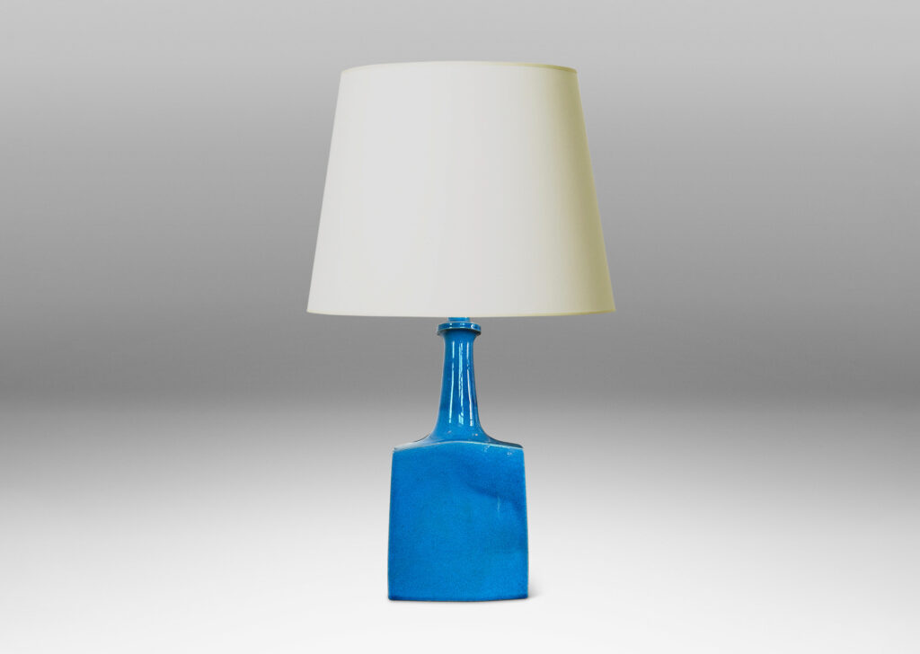 Gallery BAC bottle-like forms, having squared bases and slender sprouting necks, glazed in a saturated azure tone