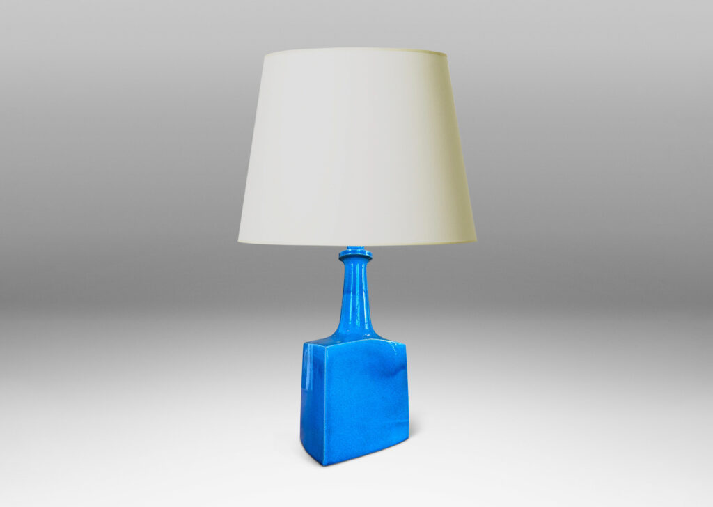 Gallery BAC bottle-like forms, having squared bases and slender sprouting necks, glazed in a saturated azure tone