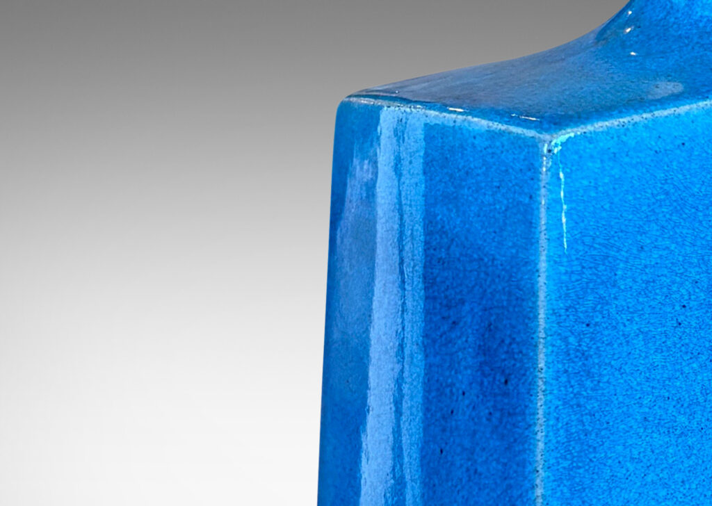 Gallery BAC bottle-like forms, having squared bases and slender sprouting necks, glazed in a saturated azure tone