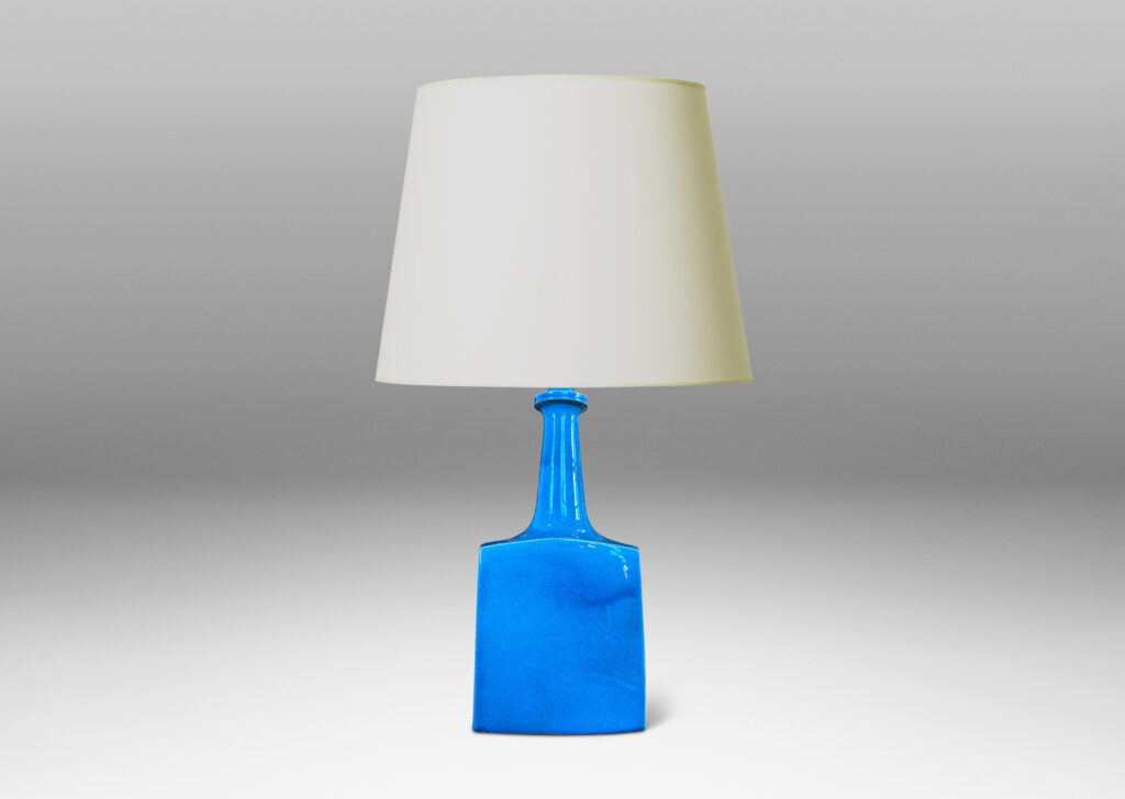 Gallery BAC bottle-like forms, having squared bases and slender sprouting necks, glazed in a saturated azure tone