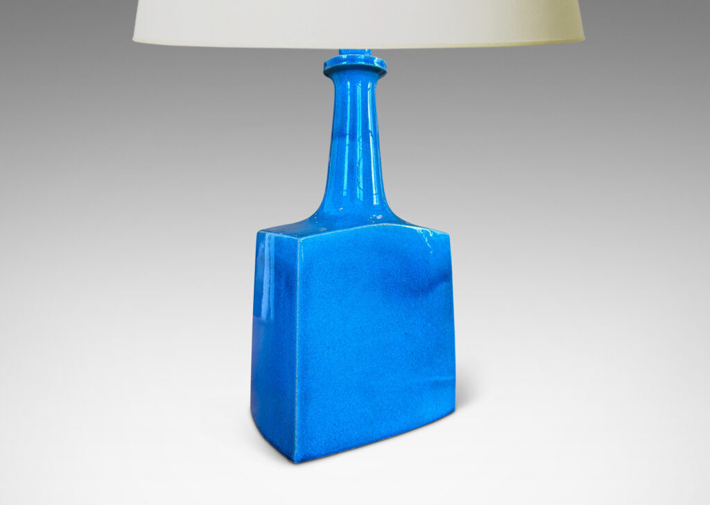 Gallery BAC bottle-like forms, having squared bases and slender sprouting necks, glazed in a saturated azure tone