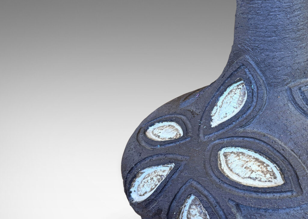 Gallery BAC compressed globe body and tall sprouting neck, ornamented with abstracted leaf-flower forms in relief, glazed in matte brown with pale gray accents