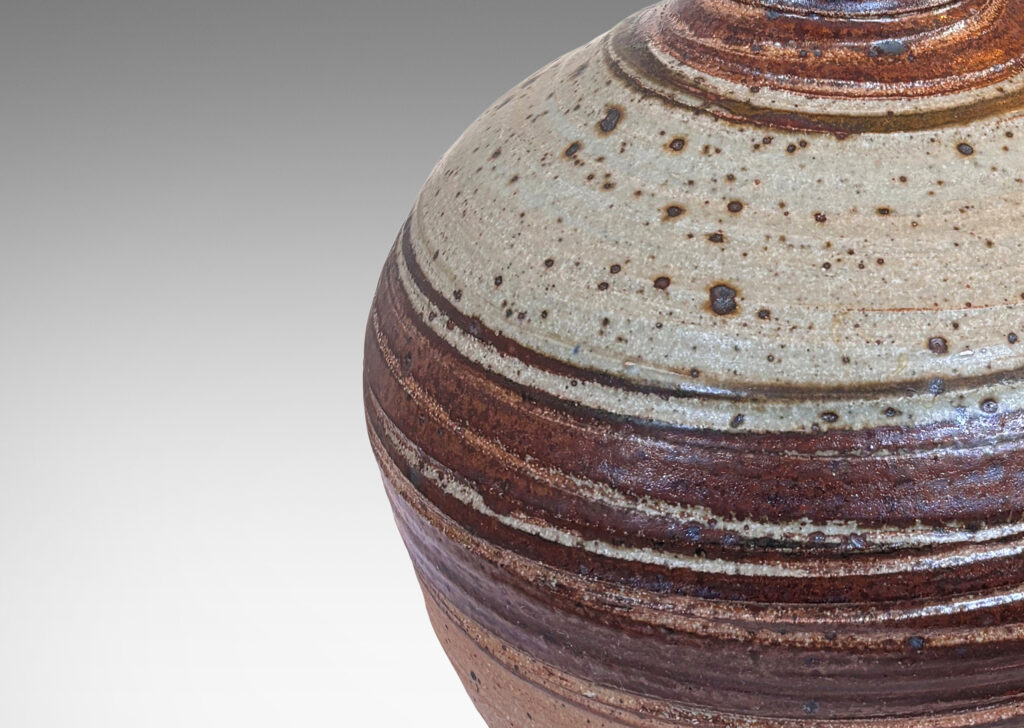 Gallery BAC spherical form with flared neck, partially glazed in dark brown and pale gray, with carved sgraffito spirals