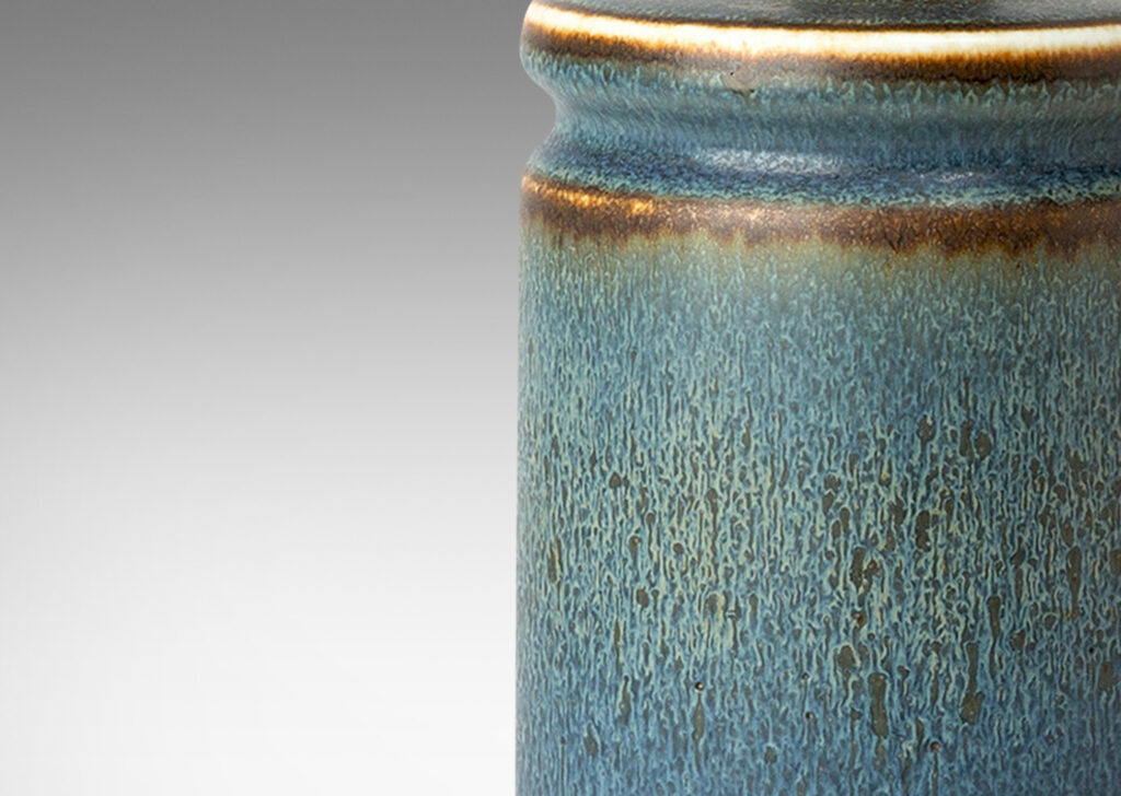 Gallery BAC cylindrical forms with exotic capped tops, glazed in a soft blue with brown