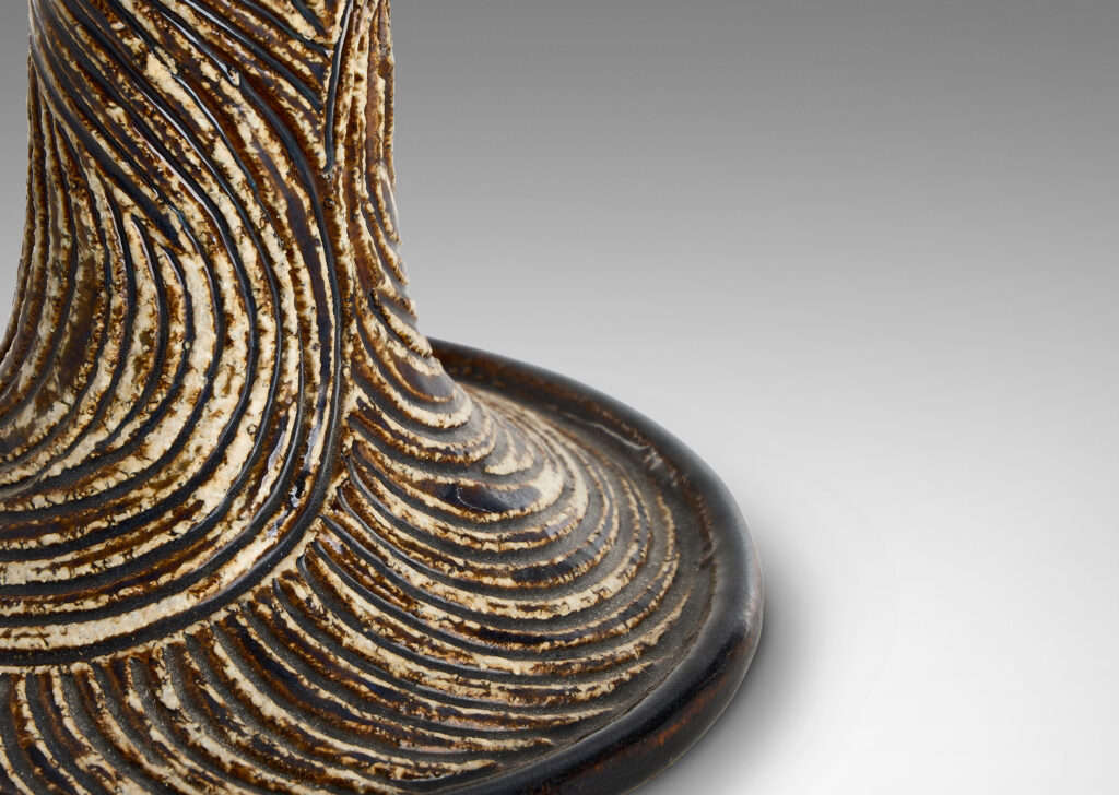 Gallery BAC flared trumpet form, carved with energetic swirling lines, glazed in brown and ivory