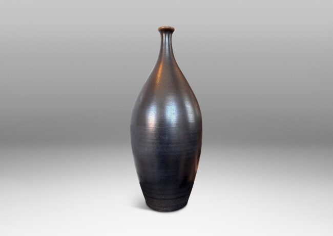 Gallery BAC swelling form with spout mouth, glazed in a dark brown with an orange peel finish