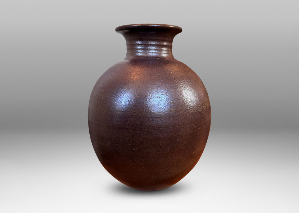 Gallery BAC globe form with wide neck and flared mouth in a dark brown salt glaze