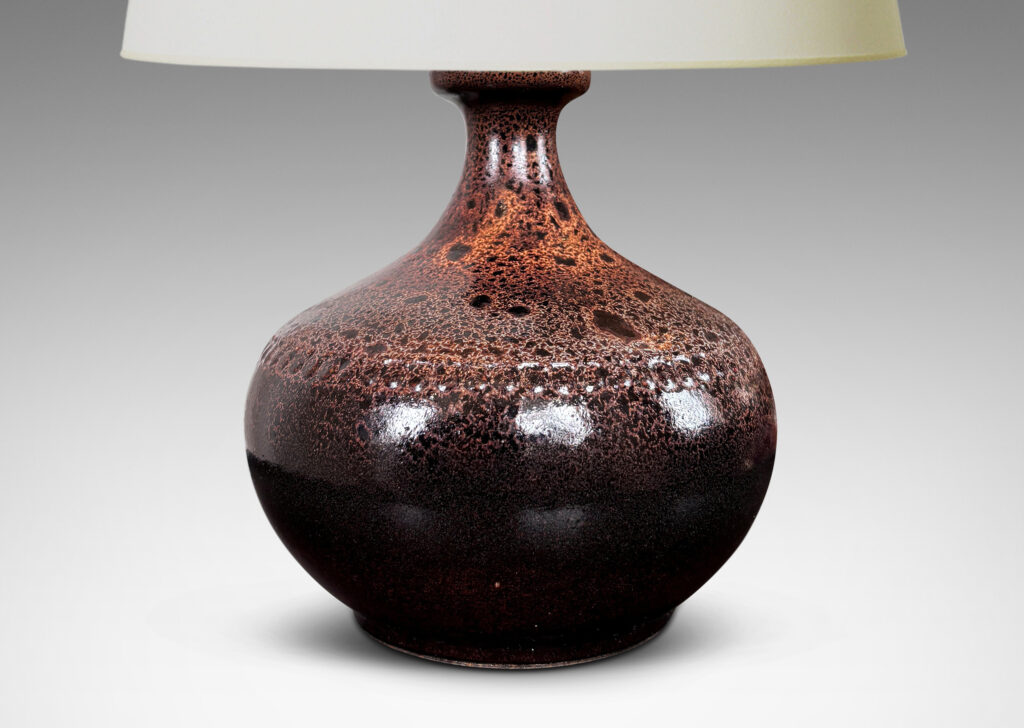 Gallery BAC low wide bulbous form with relief ring of dots; glazed in dark brown with a frothy effect on shoulders