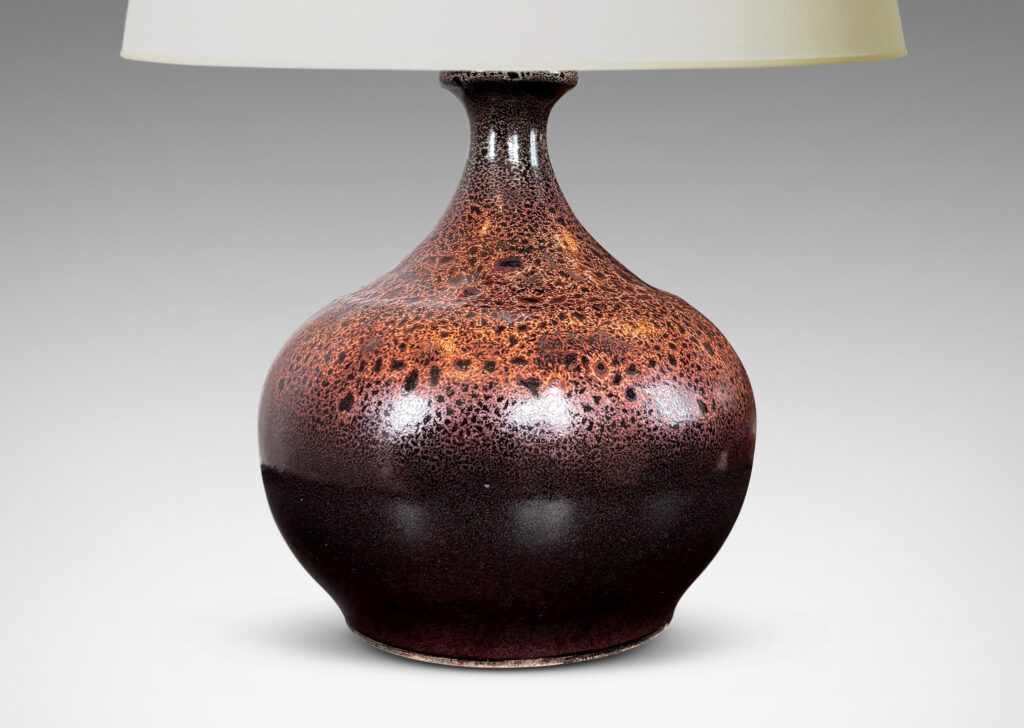 Gallery BAC low wide bulbous form with relief ring of dots; glazed in dark brown with a frothy effect on shoulders