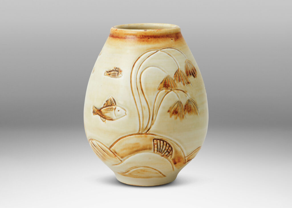Gallery BAC tulip form with carved reliefs of goldfish and water flora, glazed in a thin amber-tan with brown accents
