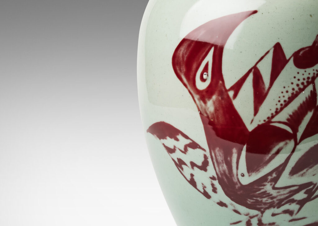 Gallery BAC tapered form and lid with branch-like finial, glazed in celadon with hand-painted abstracted fish, plants, shells and patterning in oxblood