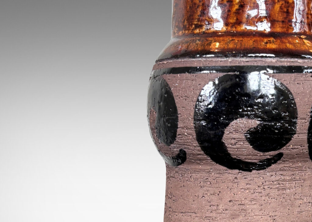 Gallery BAC subtly raked columnar form with engaged knob, glazed with swirl motifs in matte and shiny brown