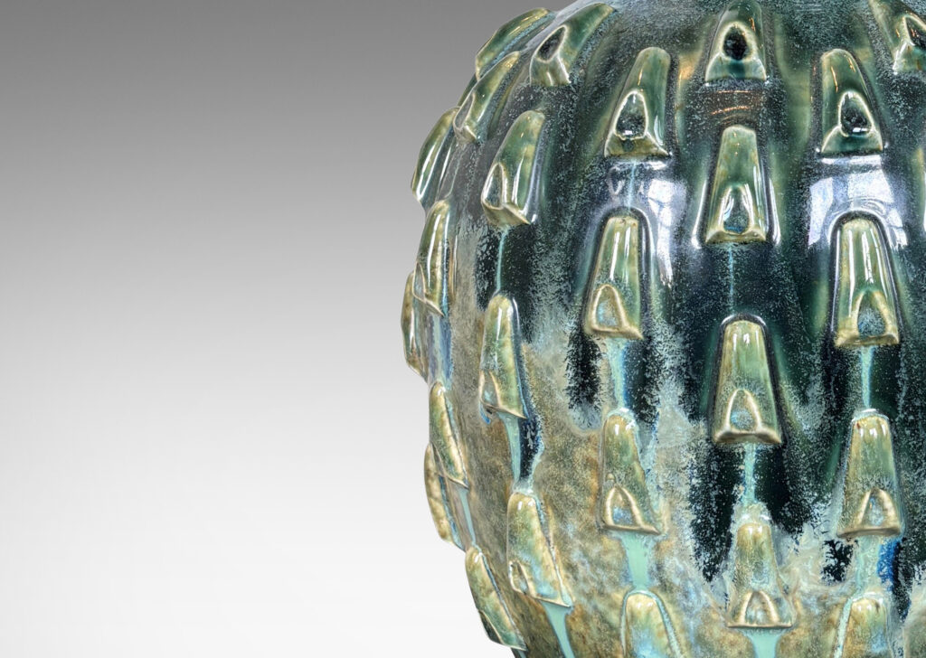 Gallery BAC tapered form with large neck and applied decorative cleats, glazed in flowing olive and teal green glazing