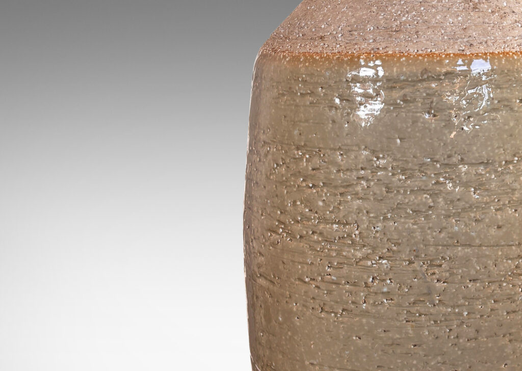 Gallery BAC swelling cylindrical form with angled shoulder and wide cuff mouth in grog ceramic with partial gloss greenish gray gloss