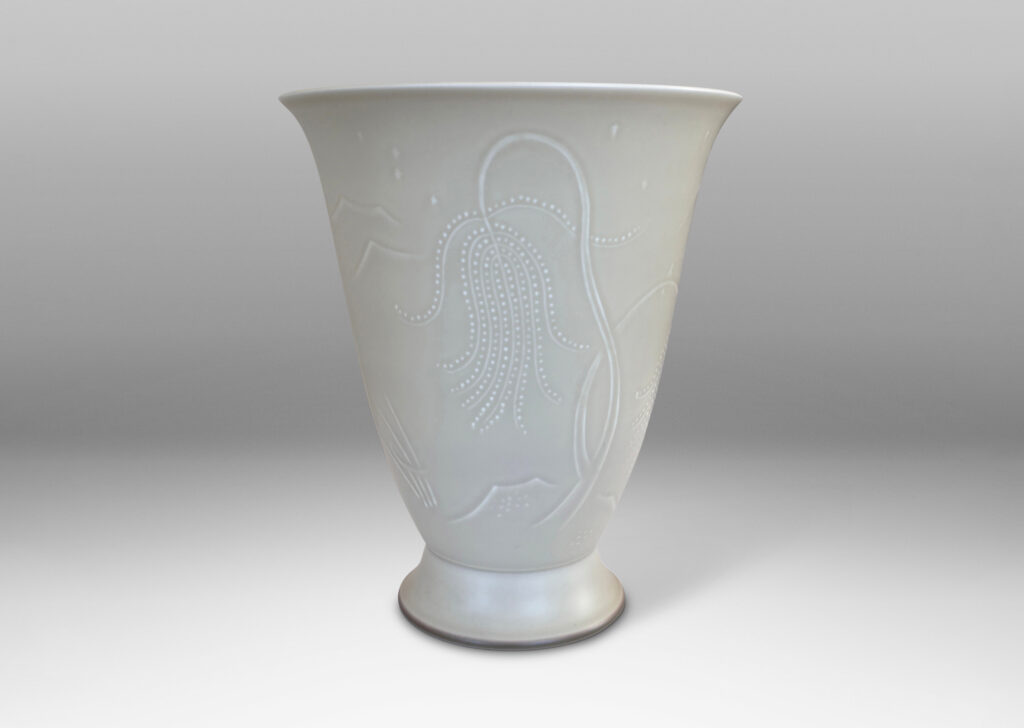 Gallery BAC lyre-form silhouette on a flanged stand, surrounded in stylized scenery in relief, glazed in a very pale gray