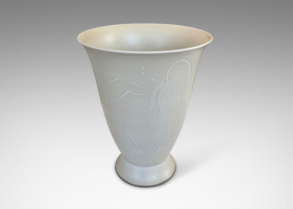 Gallery BAC lyre-form silhouette on a flanged stand, surrounded in stylized scenery in relief, glazed in a very pale gray