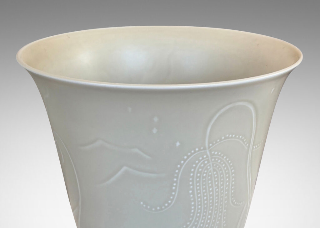 Gallery BAC lyre-form silhouette on a flanged stand, surrounded in stylized scenery in relief, glazed in a very pale gray