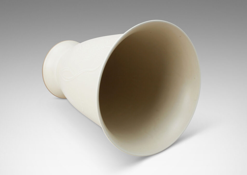 Gallery BAC lyre-form silhouette on a flanged stand, surrounded in stylized scenery in relief, glazed in a very pale gray