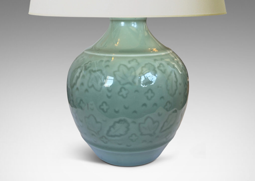Gallery BAC apered globe form with coved neck, with carved floating leaf motifs, glazed in a thick ethereal celadon green