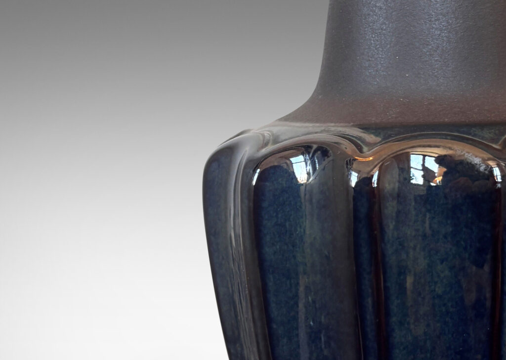 Gallery BAC pawn-like forms with a fluted drum body and conical neck, glazed in a gloss blue luster and matte brown
