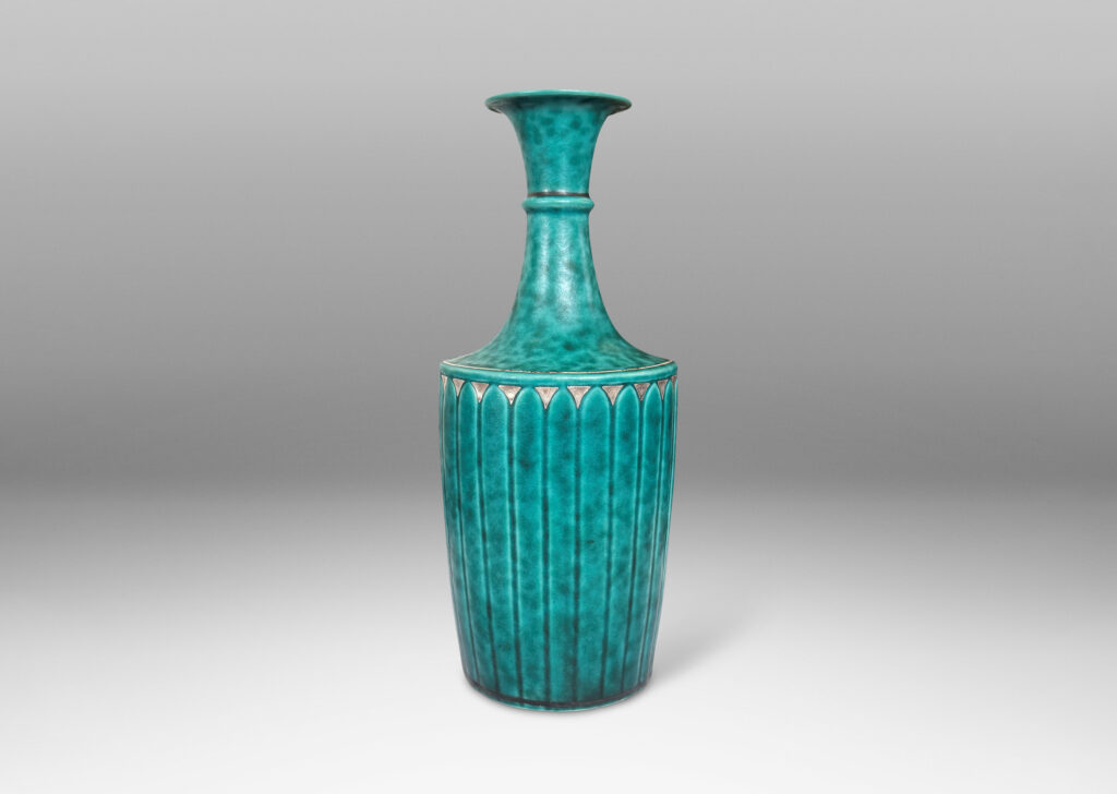 Gallery BAC tapered flited form with tall neck and flared mouth, glazed in a sponged copper oxide bluish green