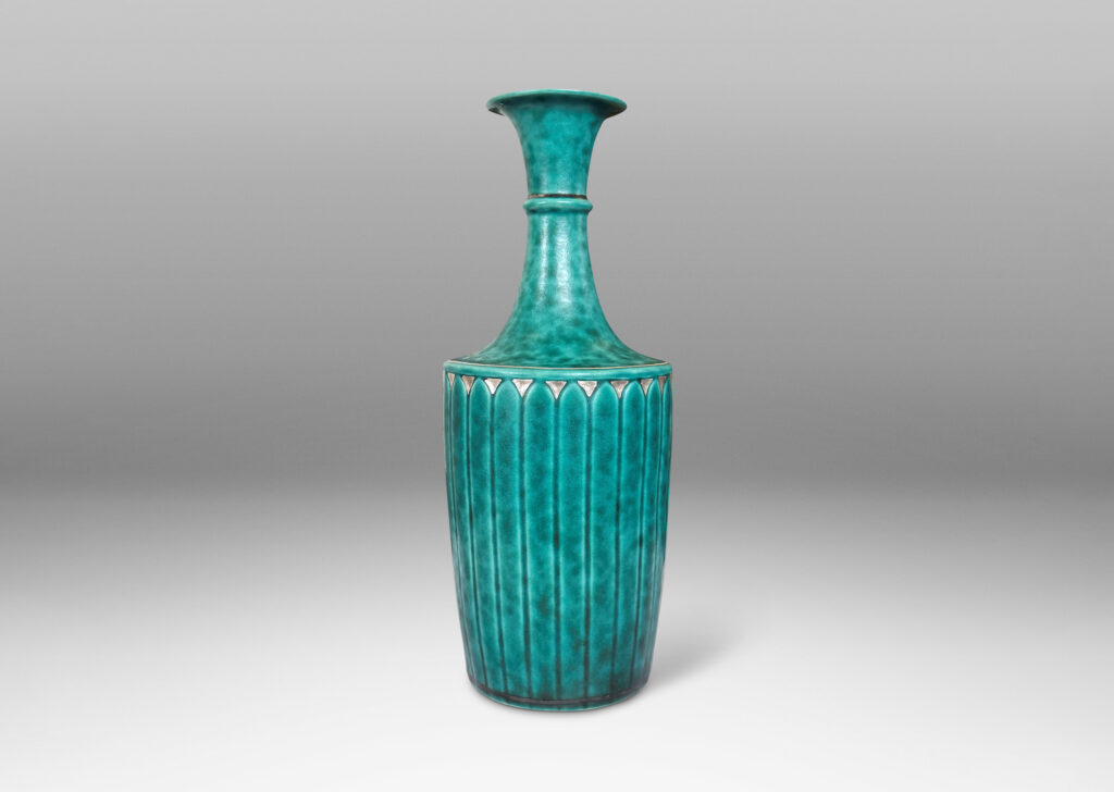Gallery BAC tapered flited form with tall neck and flared mouth, glazed in a sponged copper oxide bluish green