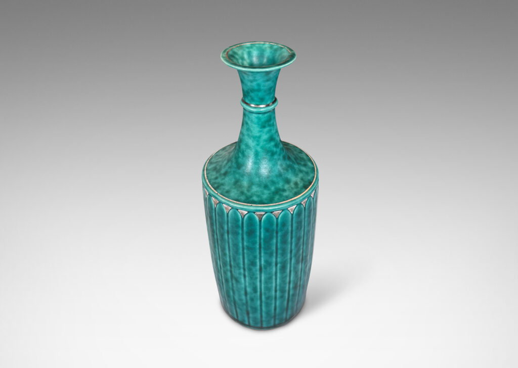 Gallery BAC tapered flited form with tall neck and flared mouth, glazed in a sponged copper oxide bluish green