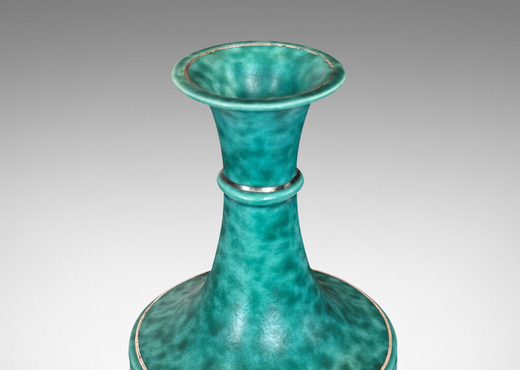 Gallery BAC tapered flited form with tall neck and flared mouth, glazed in a sponged copper oxide bluish green