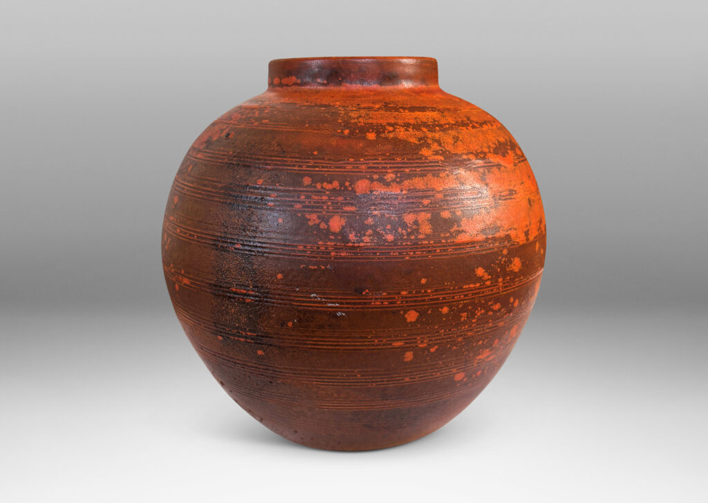 Gallery BAC globe form with carved pinstripe banding, glazed in matte orange and burnt orange brown