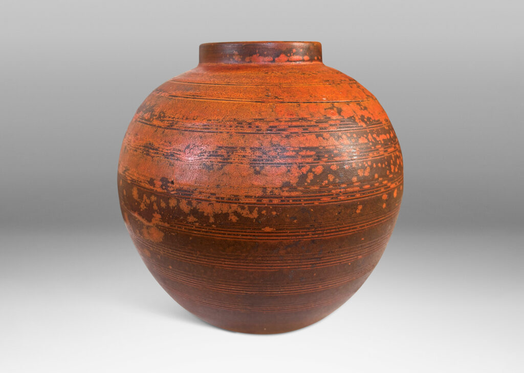 Gallery BAC globe form with carved pinstripe banding, glazed in matte orange and burnt orange brown