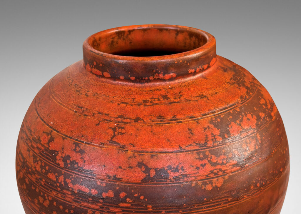 Gallery BAC globe form with carved pinstripe banding, glazed in matte orange and burnt orange brown
