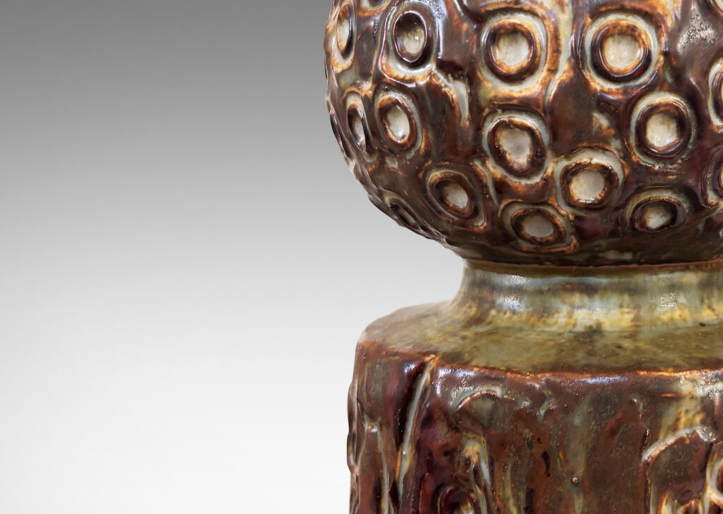 Gallery BAC bulbous cap on a cylindrical base, covered in an organic seed-pod evoking texture