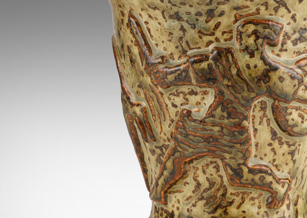 Gallery BAC onical form with undulating lip and relief mythological figures, with a masterful brown and light greige “Sung” glaze