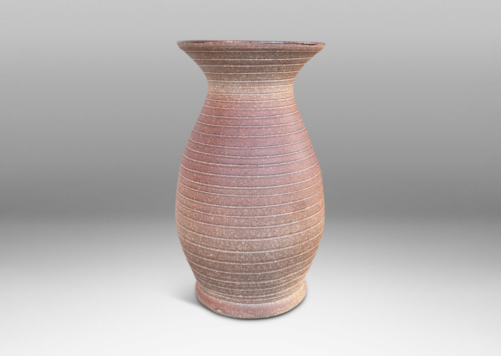 Gallery BAC tall swelling form with flared mouth and carved pinstripe spiral, partially glazed inside with an eggshell finish brown