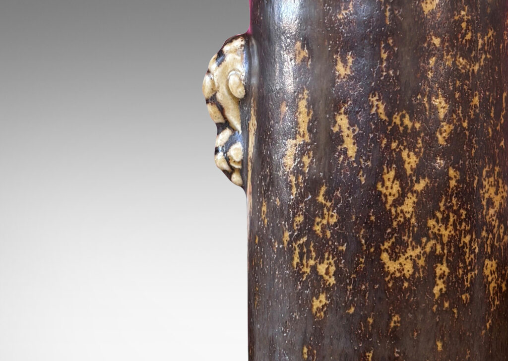 Gallery BAC cylindrical form with articulated lip and stylized floral handles, glazed in brown over pale tan