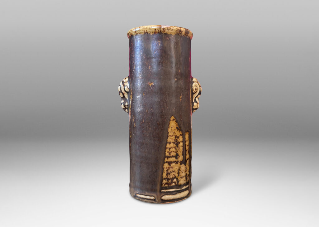 Gallery BAC cylindrical form with articulated lip and stylized floral handles, glazed in brown over pale tan