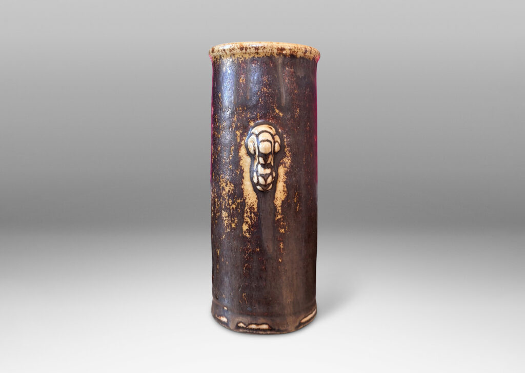 Gallery BAC cylindrical form with articulated lip and stylized floral handles, glazed in brown over pale tan