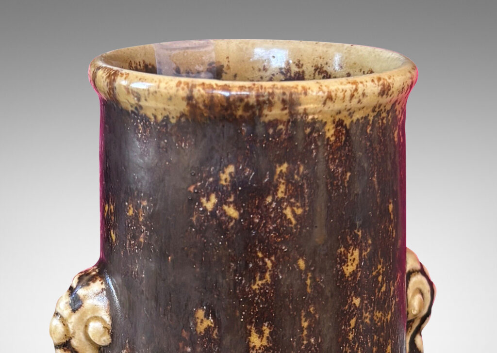 Gallery BAC cylindrical form with articulated lip and stylized floral handles, glazed in brown over pale tan
