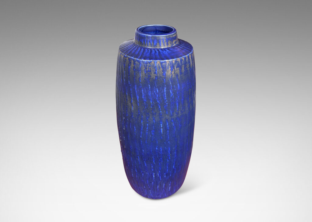 Gallery BAC swelling cylindrical form with carved gouged surface and flowing deep blue over brown glazing