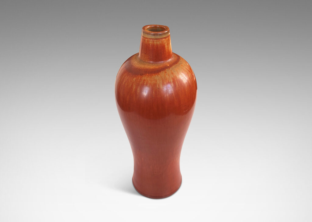 Gallery BAC sinuous form with swelling shoulders and a small conical neck, glazed in eggshell finish terra cotta orange and ochre