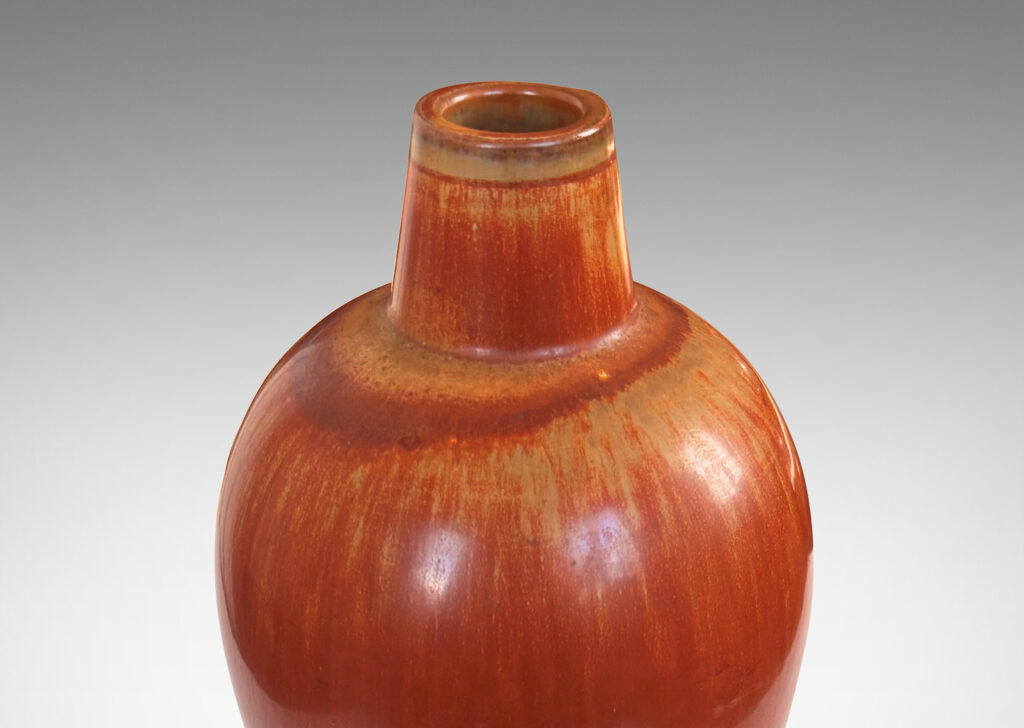 Gallery BAC sinuous form with swelling shoulders and a small conical neck, glazed in eggshell finish terra cotta orange and ochre