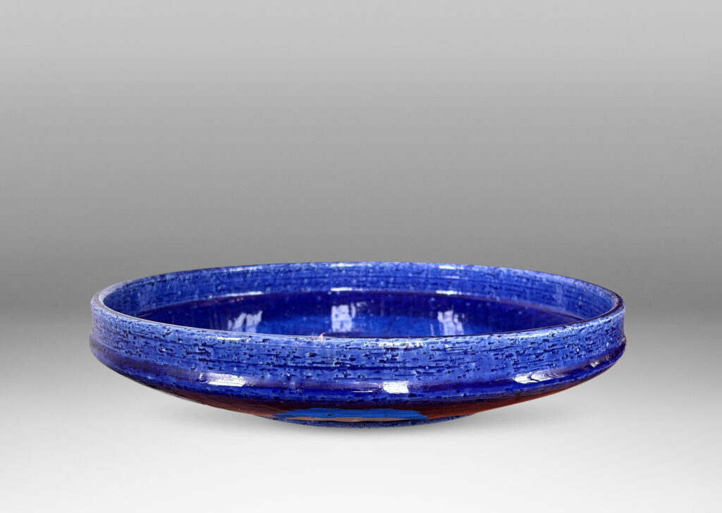 Gallery BAC wide concave form with shallow straight sides, in textured chamotte with a saturated blue glaze